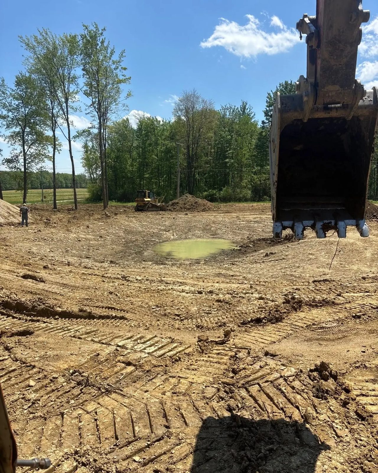 Excavator bucket over a freshly graded and dug site